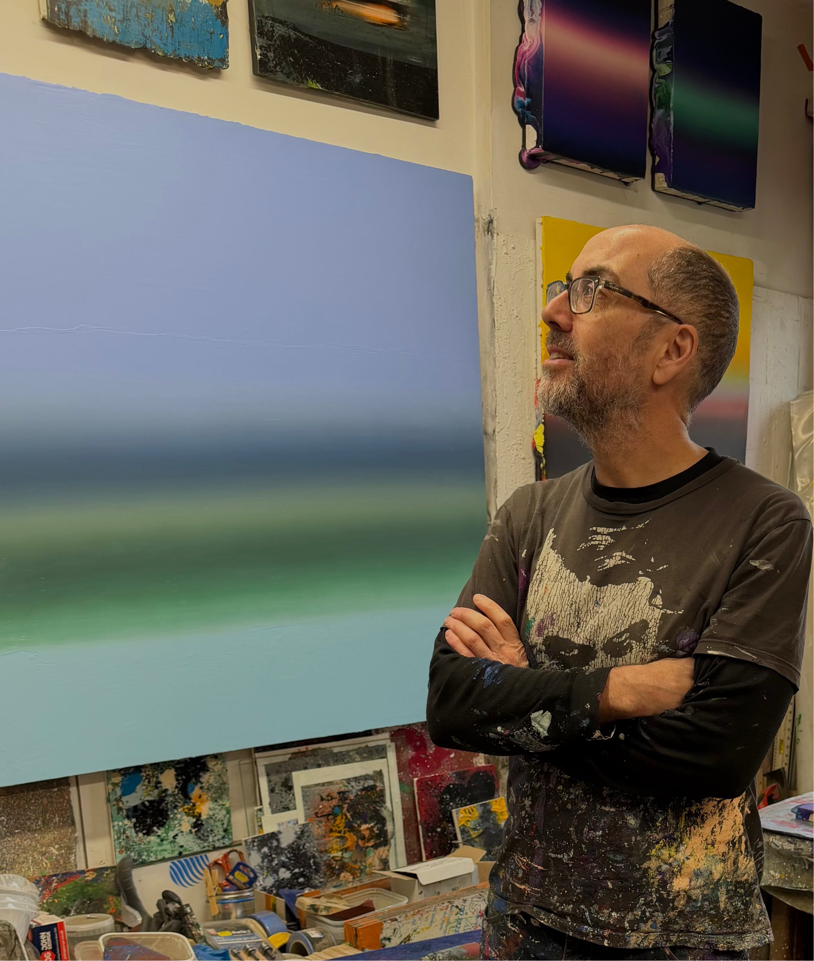 Renowned contemporary Welsh artist Elfyn Lewis standing in his studio, known for his abstract landscape paintings inspired by the horizon and shift in day-light. 