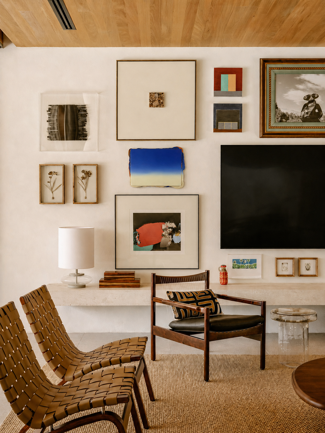 Living room with gallery wall art, chairs, and a television inspired by mid-century decor. Contemporary artwork by welsh artist Elfyn Lewis. 