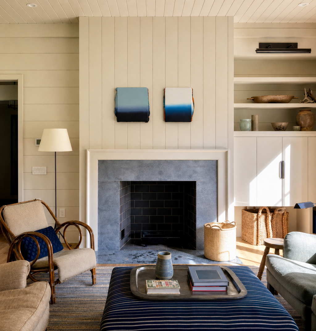 Living room with a fireplace, armchair, and coffee table. Artworks by Welsh Contemporary Artist Elfyn Lewis.