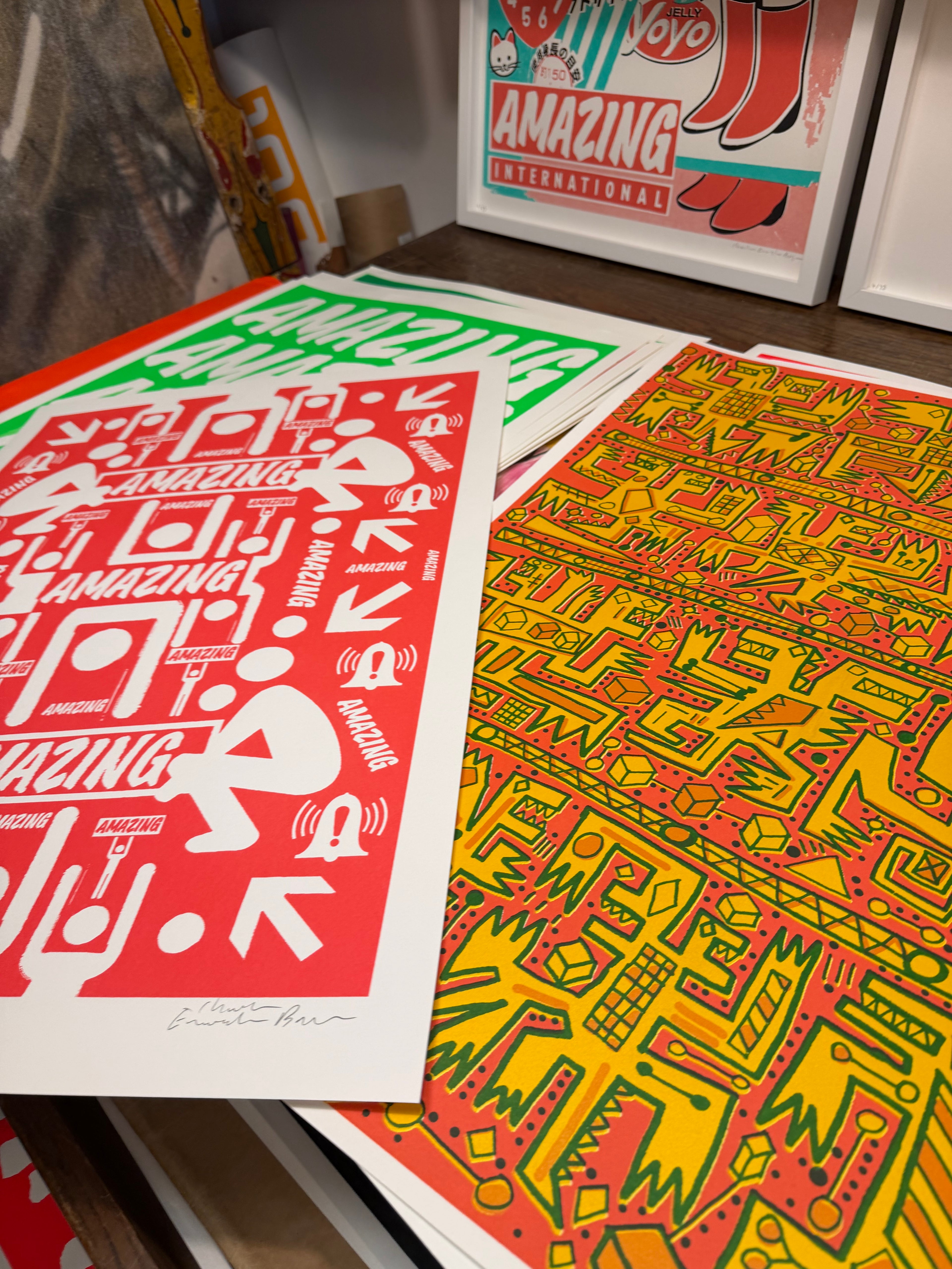 Colorful graphic prints on paper with 'Amazing' text and geometric designs.