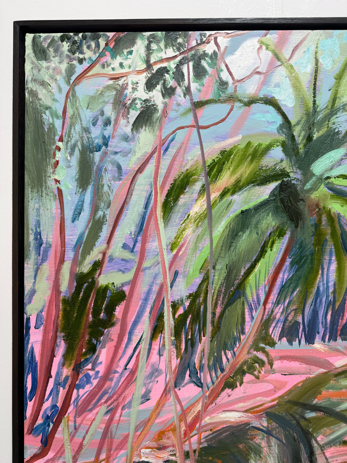 Last of the Bajan Red Mangroves 2026 by Hannah Rollings, original contemporary landscape painting inspired by Barbados. A close-up of a framed painting depicting a tropical scene with green palm-like leaves and pink and blue brushstrokes. 