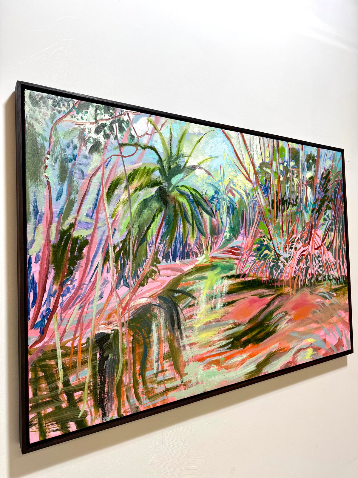 A framed abstract landscape painting featuring vibrant green palm trees, pink and orange brushstrokes, and blue and white highlights. Buy contemporary art for your home: Last of the Bajan Red Mangroves 2026 by Hannah Rollings, original contemporary landscape painting inspired by Barbados