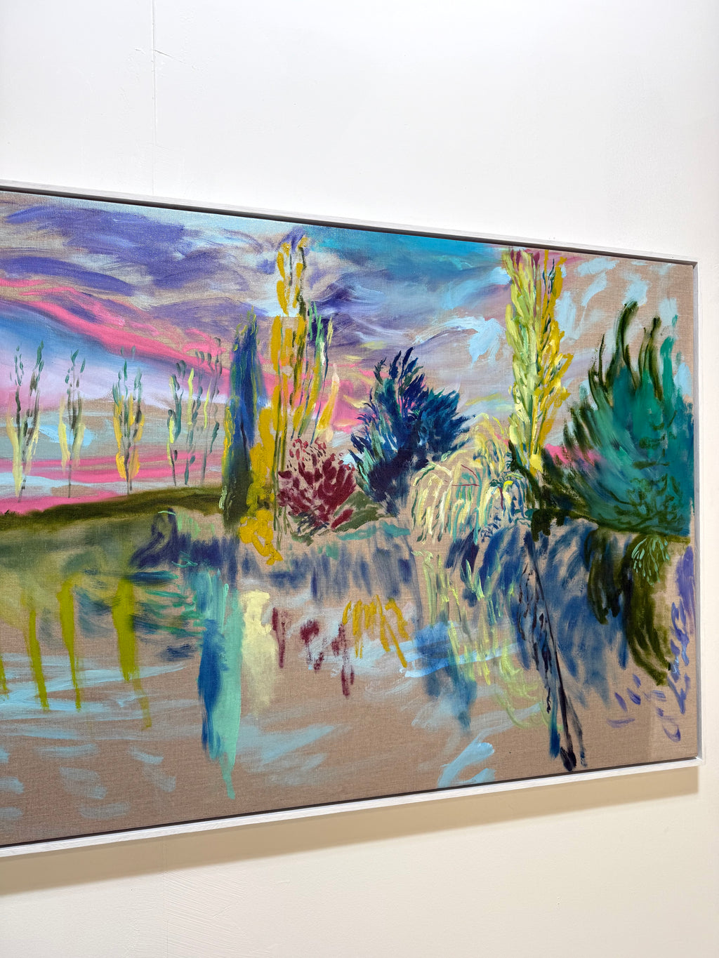 A colorful landscape painting hanging on a white gallery wall. The artwork features expressive brushstrokes with blue, purple, pink, green, yellow, and brown tones, depicting trees, foliage, and a reflective water scene.
Eure Valley, After Monet 2026 by Hannah Rollings, original expressive landscape painting inspired by Normandy and Monet